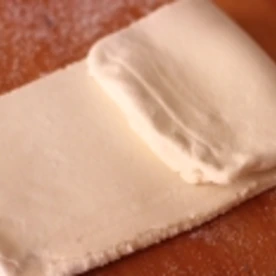 綺麗に層になるのか確認できる、折りこみパイ生地のお菓子パピヨンを作る工程でたたみこむ内側にもグラニュー糖をふりかけたところ。